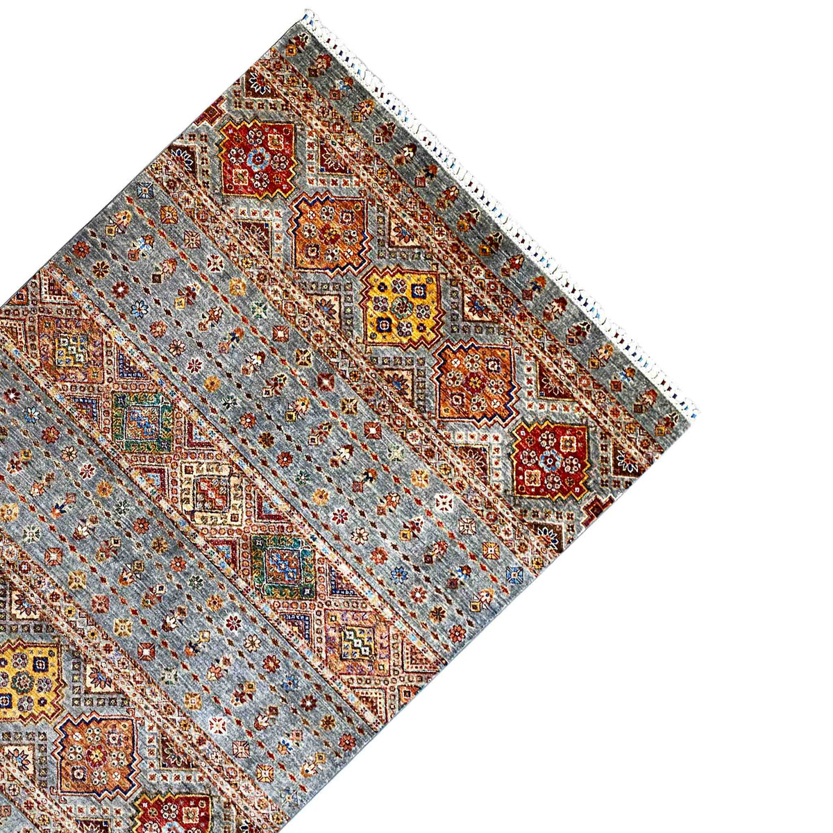 Carpet corner with geometric diamond shapes, a gray background, and a decorative border, with fringes visible