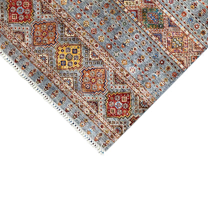 Rug edge with fringe and geometric quadrilaterals in gray, red, and yellow, shown in detail