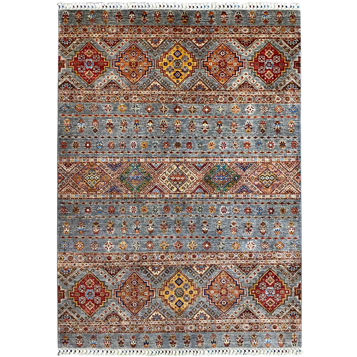 Rug with a geometric tribal design in gray, red, blue, yellow, and white fringe