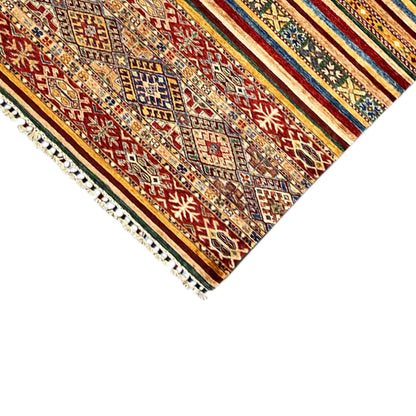 Corner of a runner rug with tassels, multicolored patterns, and stripes