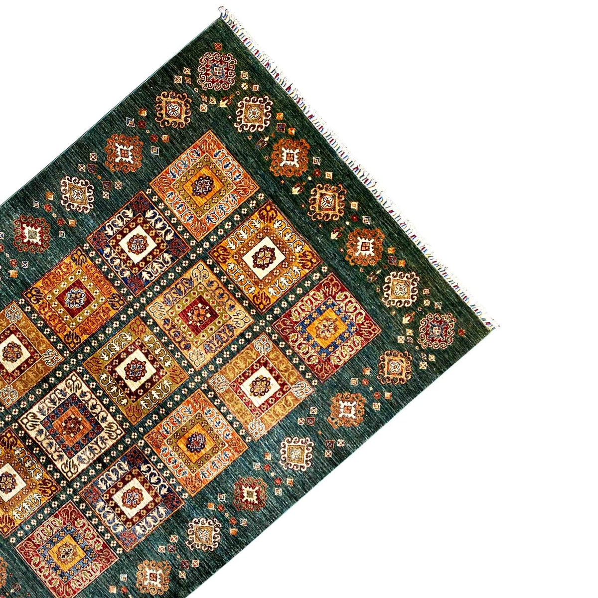 Rug from the corner: blue-green, symmetrical tiles with ornaments, fringes all around