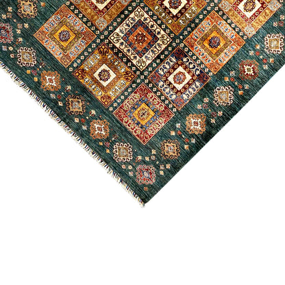 Rug corner with a blue-green pattern and multicolored border, fringes along the edge