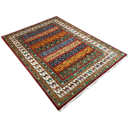 Carpet spread out with a geometric pattern, colorful border, and animal motifs along the edges