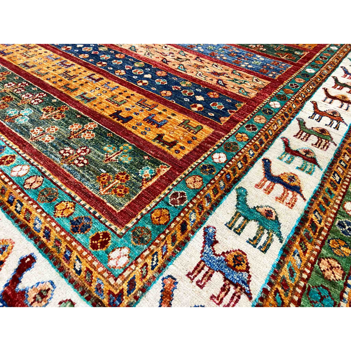 Close-up of carpet details with colored fields, ornaments, and animal motifs along the edge