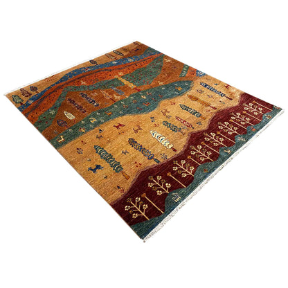 Landscape rug made of colorful yarn with mountains, paths, and rows of trees, photographed at an angle.