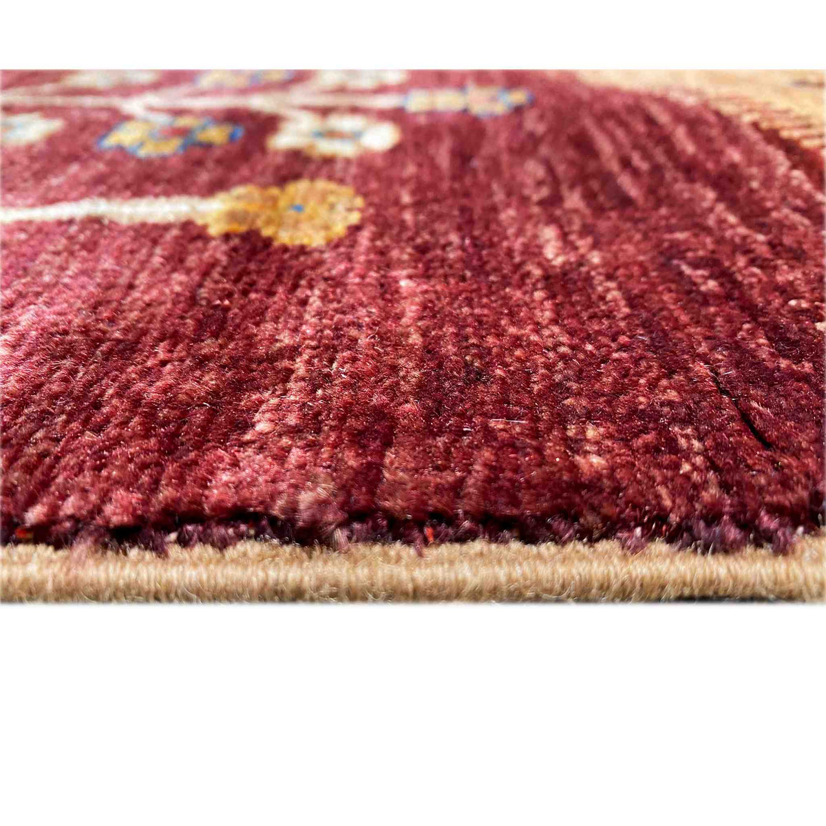 Close-up: red pile of a rug with a dense weave and a fine edge.
