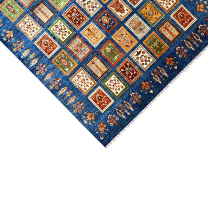 Blue rug with colorful square tiles and fringes, diagonal view
