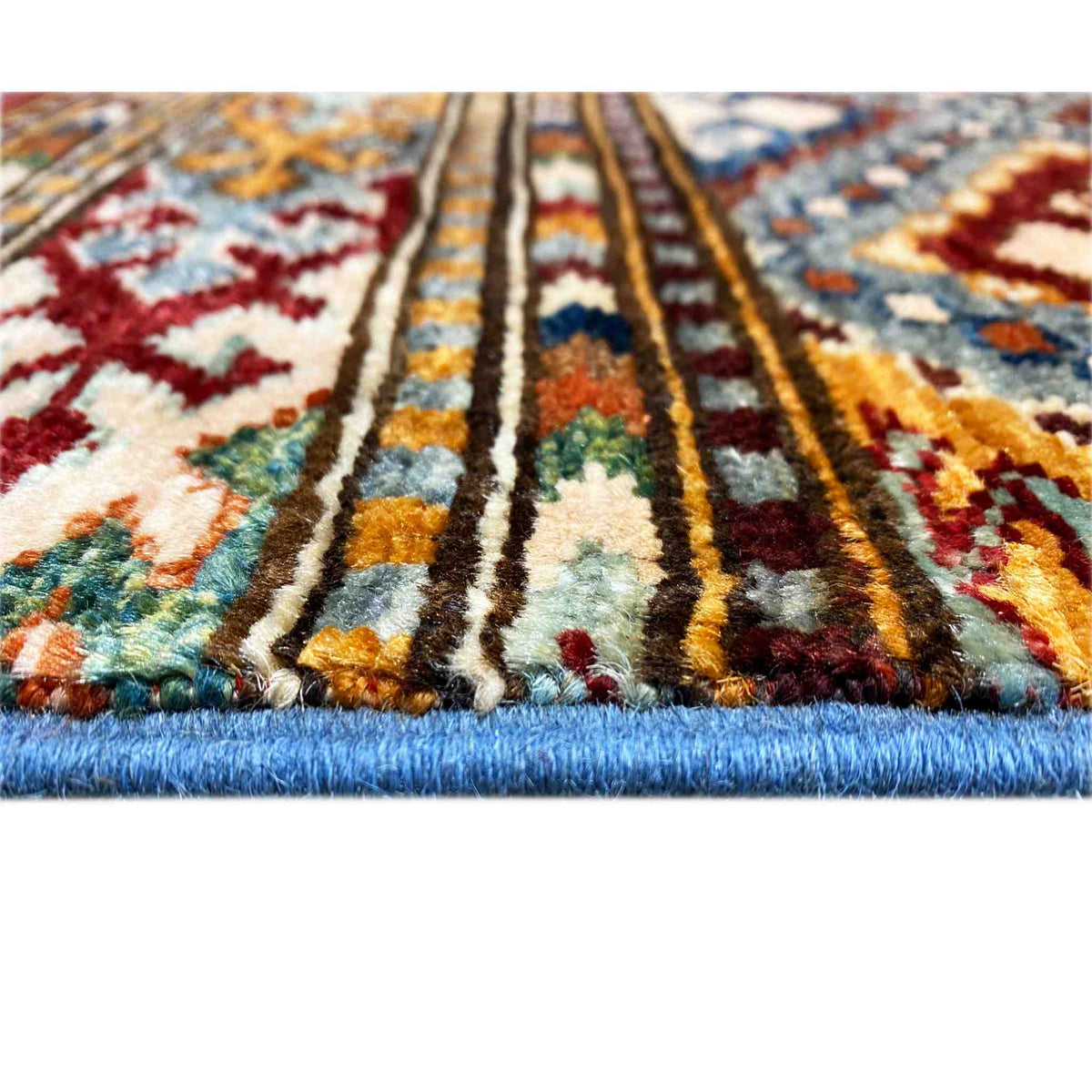 Rug detail with a colorful pattern and thick pile edge, visible fringes along the border