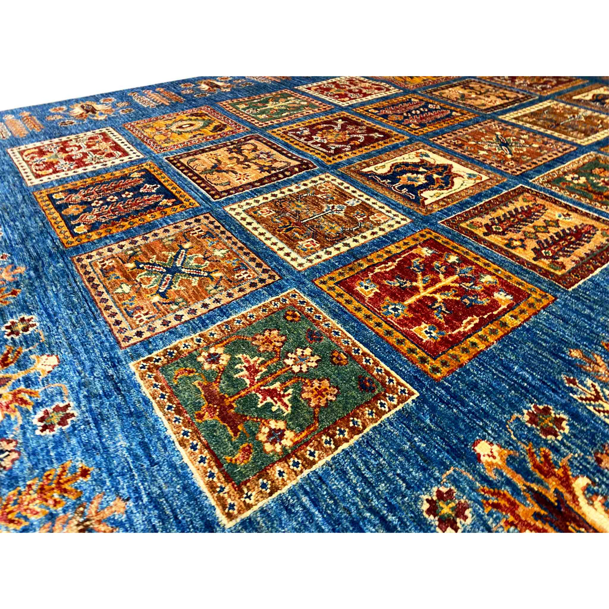 Khorjin rug close-up: blue with colorful square motifs and an ornate border pattern