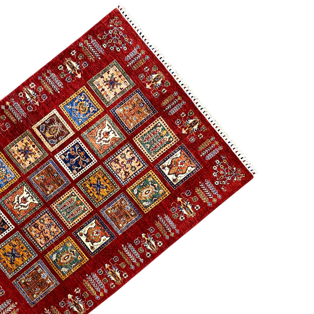 Red carpet corner with colorful squares, a fine pattern, and white fringe trim