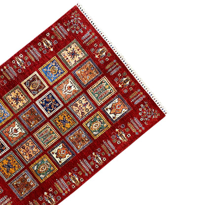 Red carpet corner with colorful squares, a fine pattern, and white fringe trim