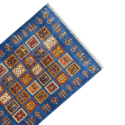 Rug with an azure-blue background, a centered square pattern, side border, and fringed edge
