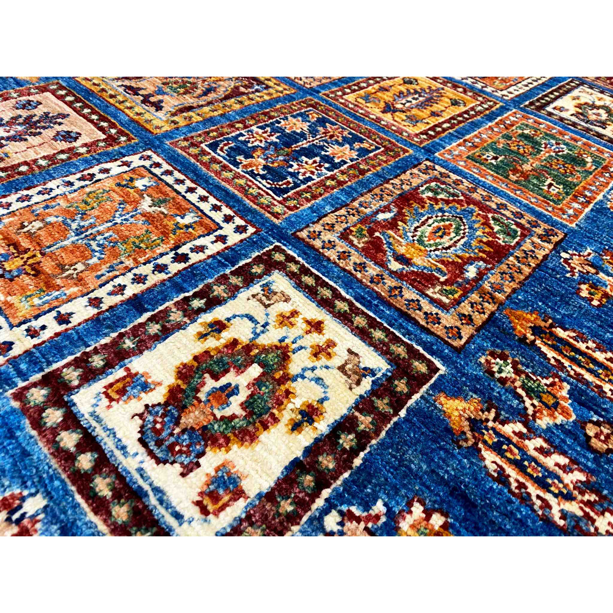 Close-up: blue carpet pattern with colorful squares and woven ornaments