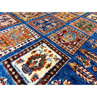 Close-up: blue carpet pattern with colorful squares and woven ornaments