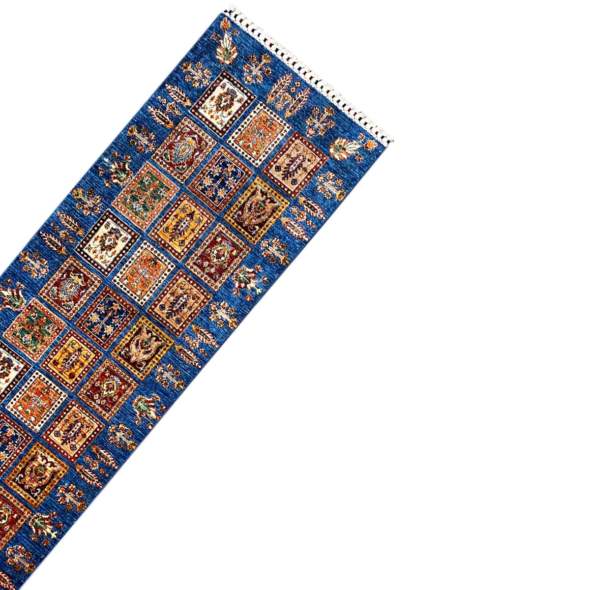 Runner rug corner: blue pattern with colorful squares and a white fringed edge
