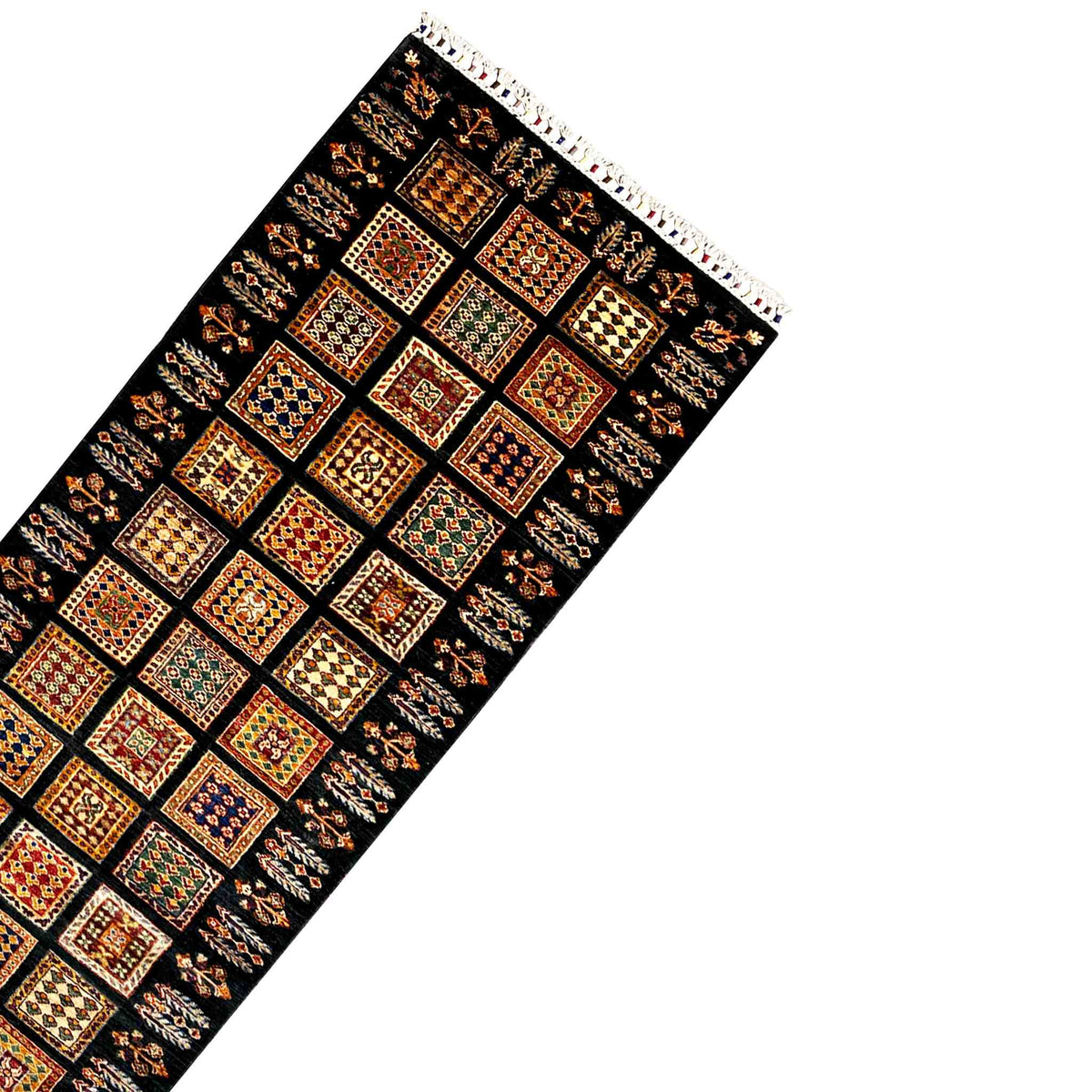 Runner rug corner with fringe trim and a dense square pattern on dark background