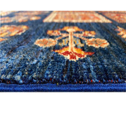 Close-up: wool rug with a dark blue pile and colorful ornaments along the edge with an overlock stitch