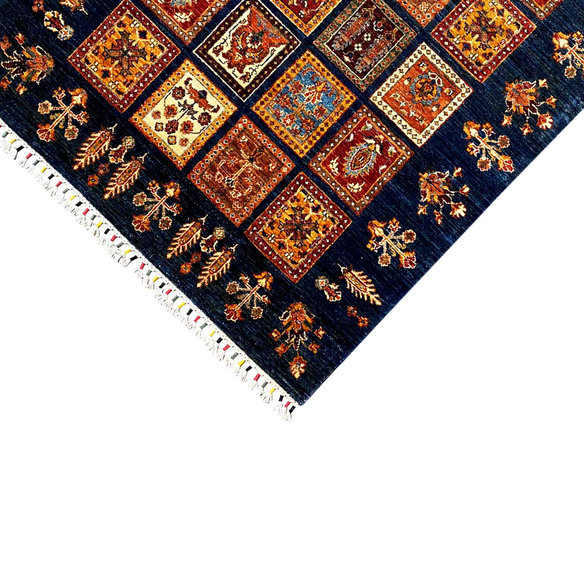 Corner of a wool Khorjin rug: dark blue with tile ornaments and white fringes