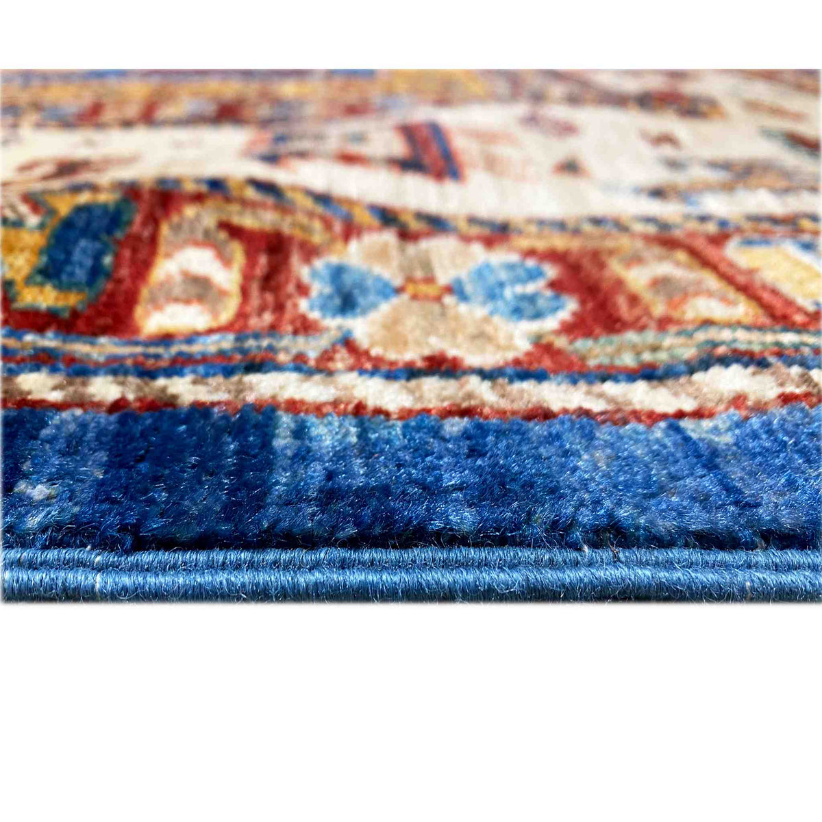 Carpet detail: dense pile with a blue border and colorful patterns