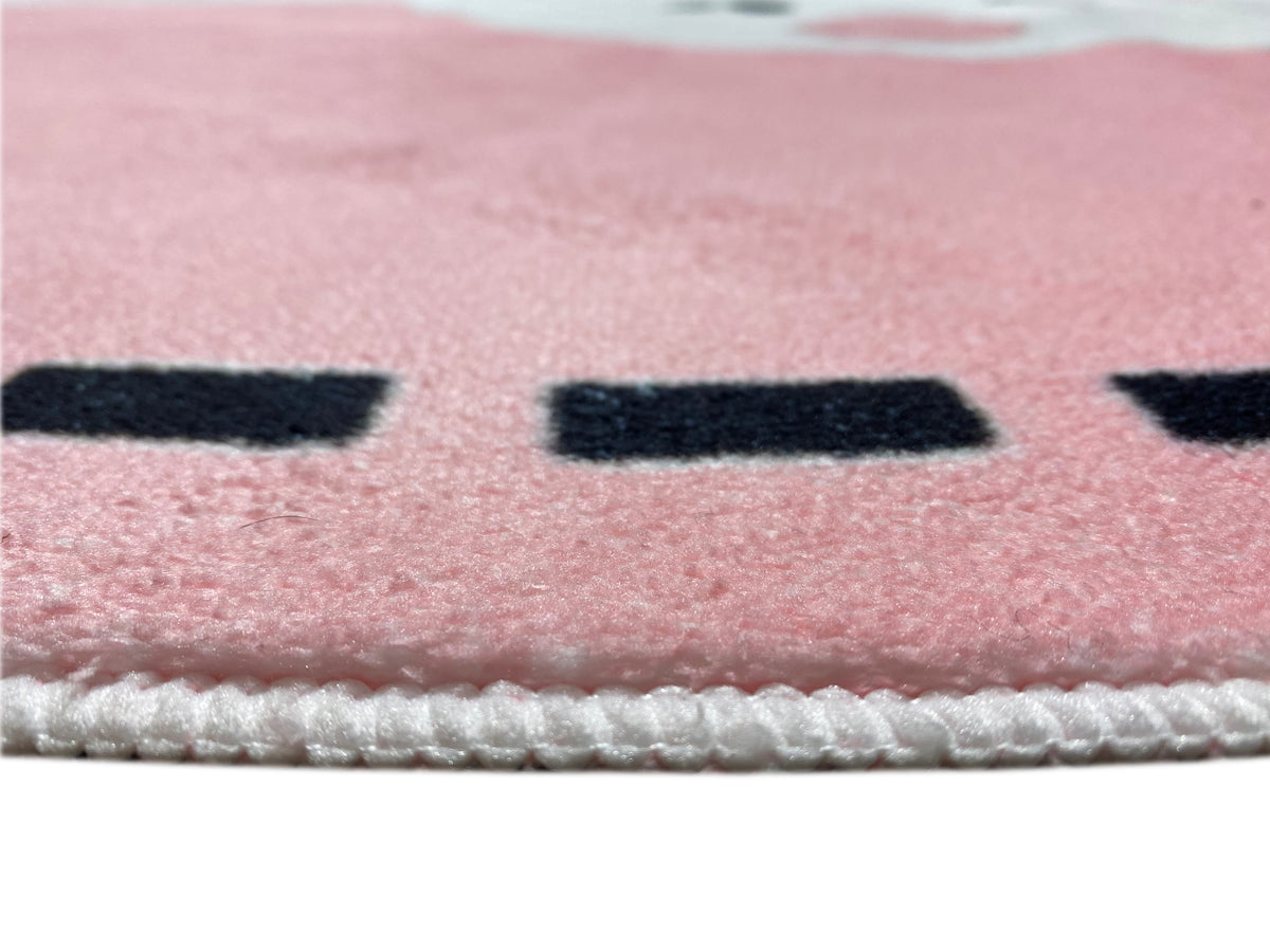 Nahaufnahme Teppichkante mit Ziernaht und Flor auf rosa Oberfläche