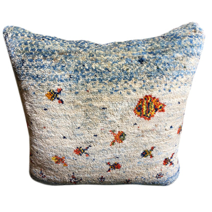 Square cushion with a blue patterned background and colorful ornamental motifs on light fabric