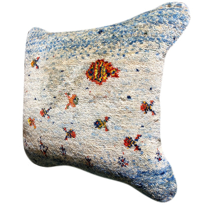 Light blue/white cushion cover with colorful ornaments, three-quarter view