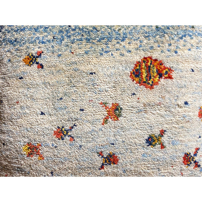 Close-up of the cushion fabric: blue-and-white texture with colorful embroidered ornaments