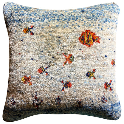 Square cushion with blue-and-white textured fabric and multicolored animal/floral motifs