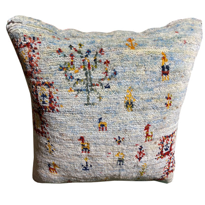 Light blue decorative cushion with colorful embroidered figures on the front