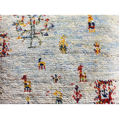 Close-up: light-colored cushion with a coarse weave and colorful embroidered figures