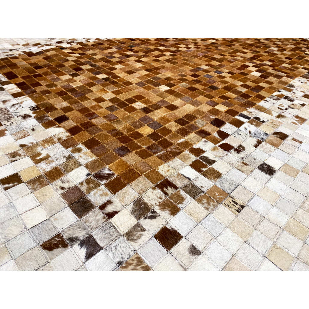 Close-up of a calfskin rug: brown-and-white patchwork tiles with contrasting spots