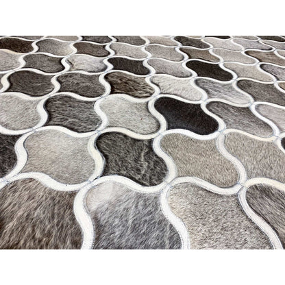 Close-up of a calfskin rug: trefoil-like frames alternating between gray and white