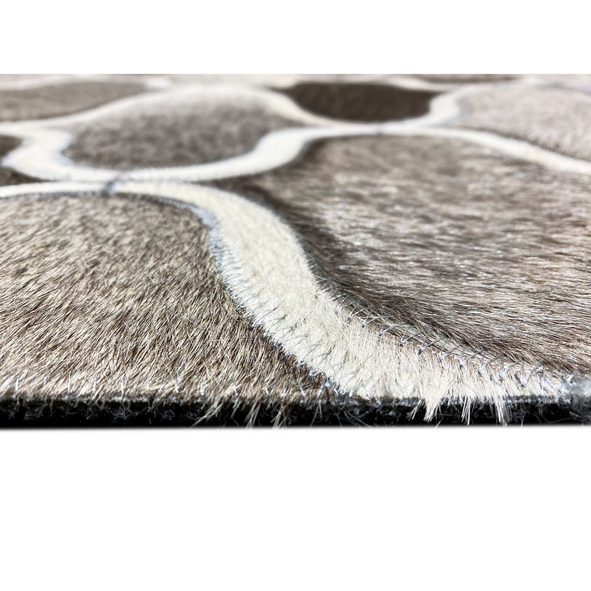 Close-up of the edge of a calfskin rug: short fur with a white-bordered pattern