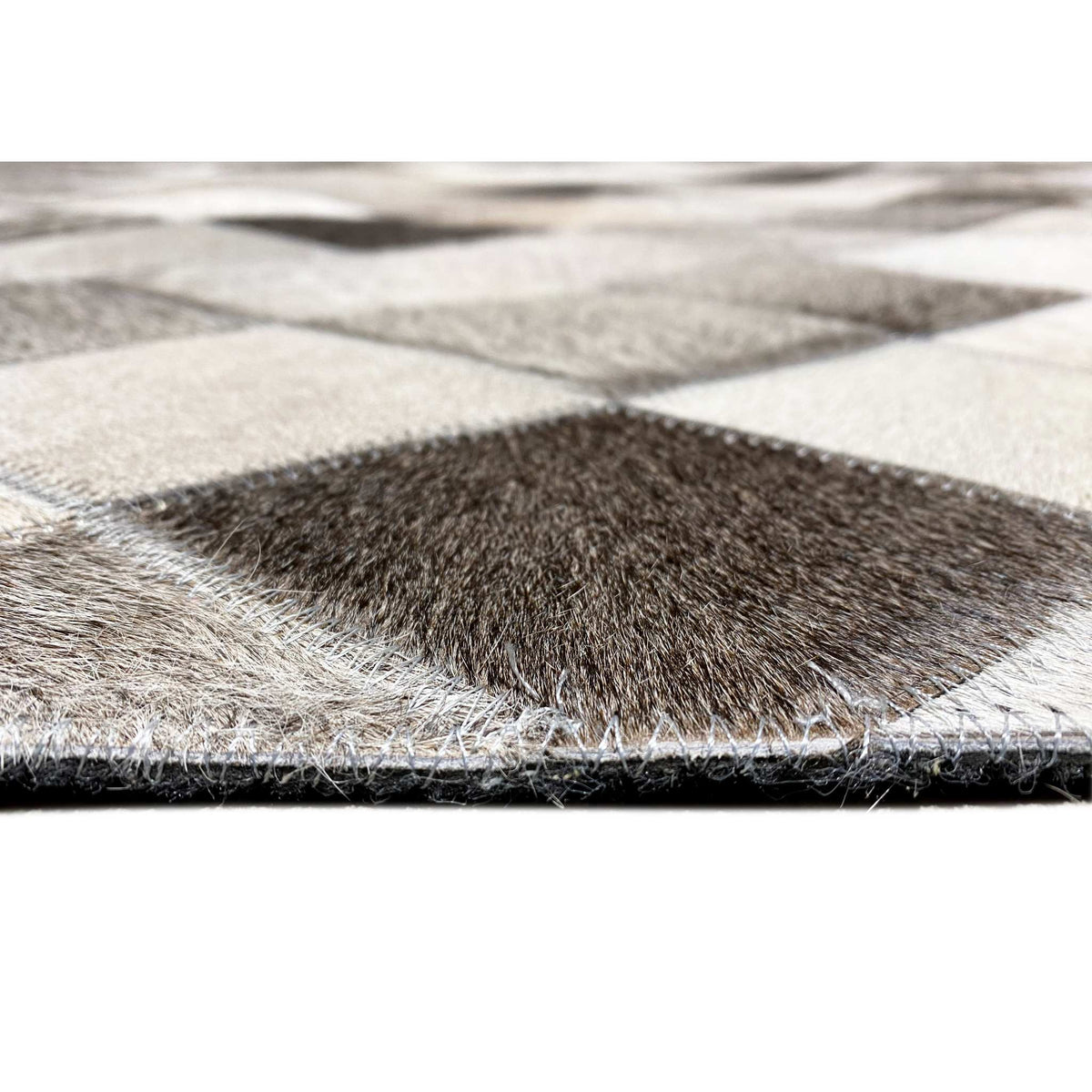 Edge view of the leather rug with fur surface and diamond pattern, black-gray-white