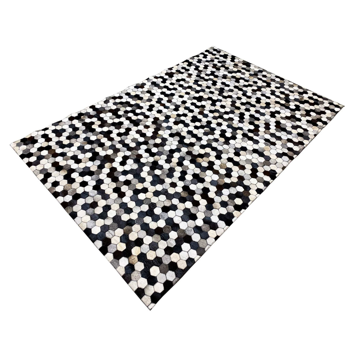 Calfskin rug with a hexagonal pattern, positioned diagonally, high-contrast black-and-white sections