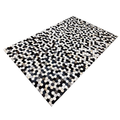 Calfskin rug with a hexagonal pattern, positioned diagonally, high-contrast black-and-white sections