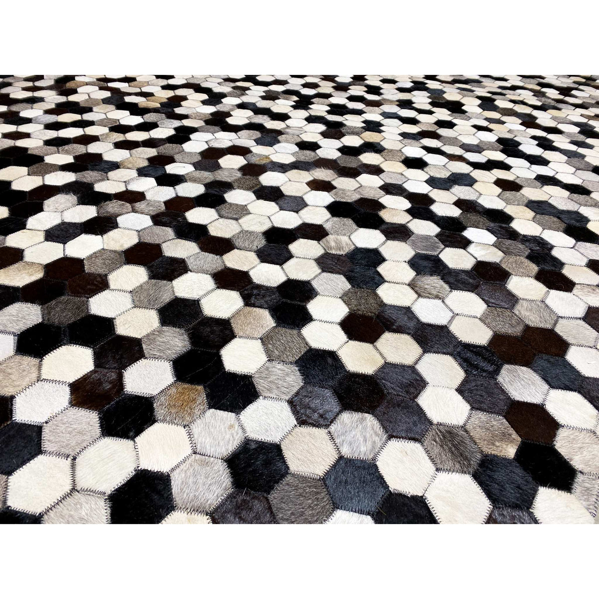 Close-up view of the hexagon pattern on a calfskin rug in black, white, and shades of gray