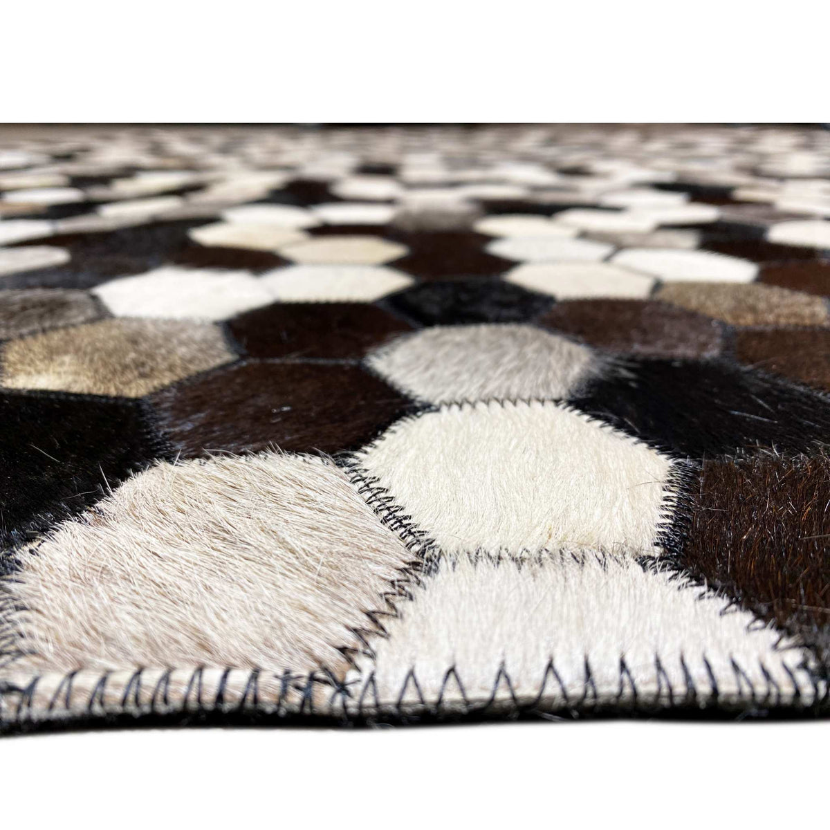 Close-up: hexagonal pattern with visible pile texture and a sewn carpet edge along the border
