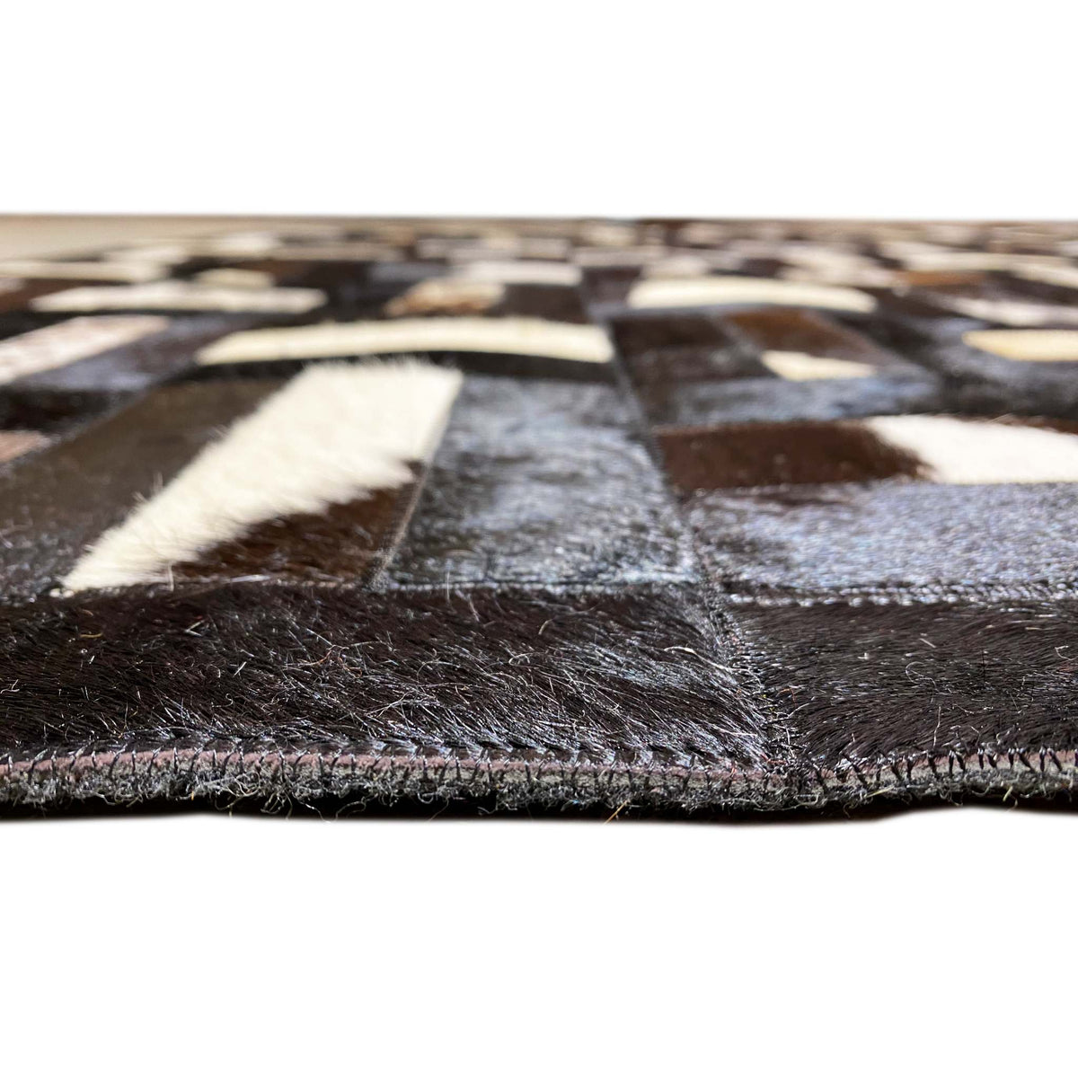 Calfskin rug with a geometric pattern and visible pile edge, black and gray