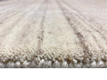Teppichunterkante im Detail: weiche Florstruktur mit beigen und grauen Fleck-Übergängen