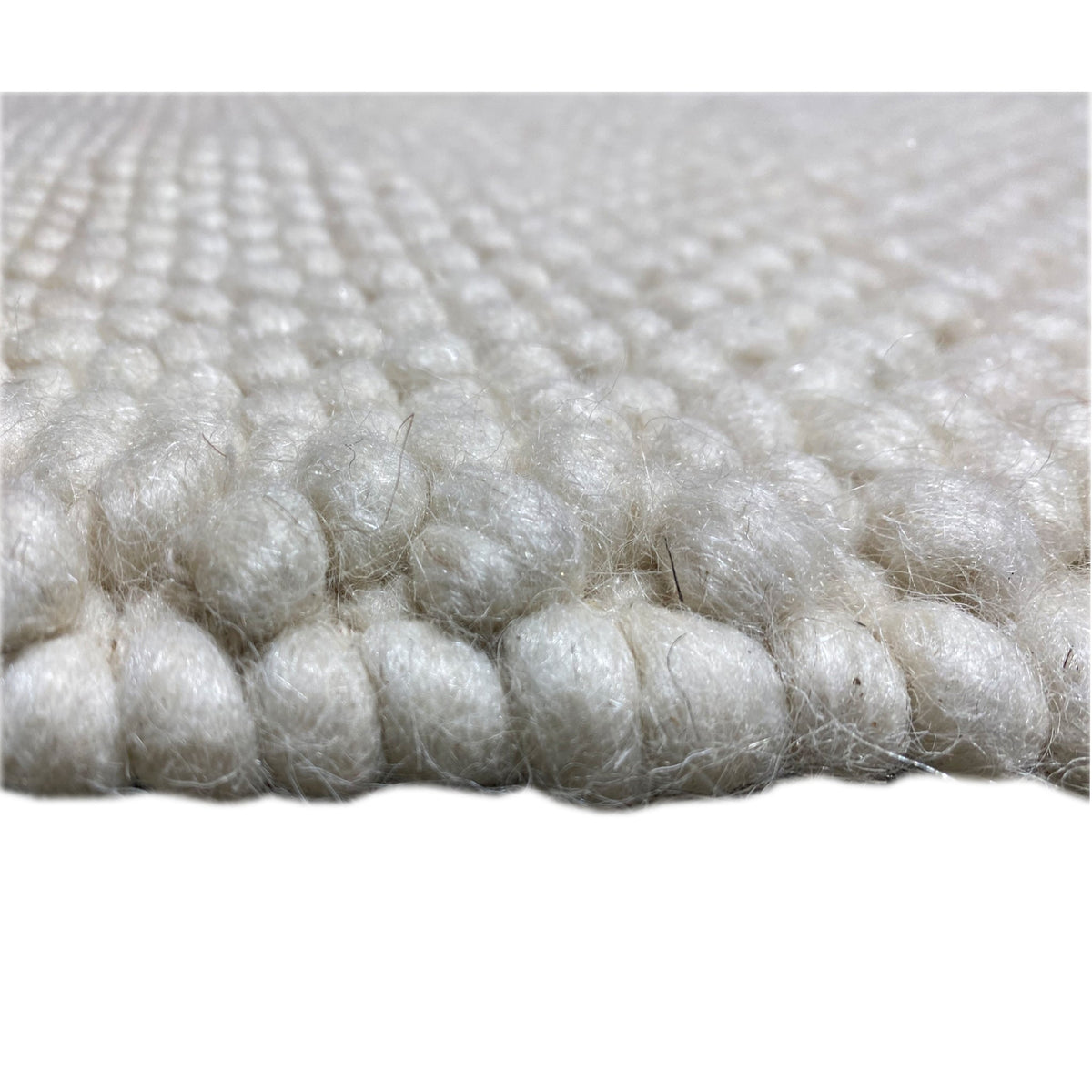 Carpet, close-up: white/light beige wool pile with dense felt nubs