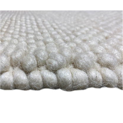 Carpet, close-up: white/light beige wool pile with dense felt nubs