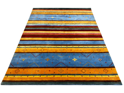 Loom Luri Teppich von oben: gleichmäßige Streifen in Blau, Orange, Rot und Grün.