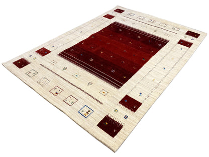 Loom Luri Teppich mit cremefarbenem Hintergrund, rotem Zentrum und farbigen Eckmotiven