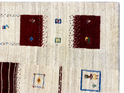 Loom Luri Teppich Nahansicht der Fläche: cremefarben, mit roten Quadraten und Symbolen