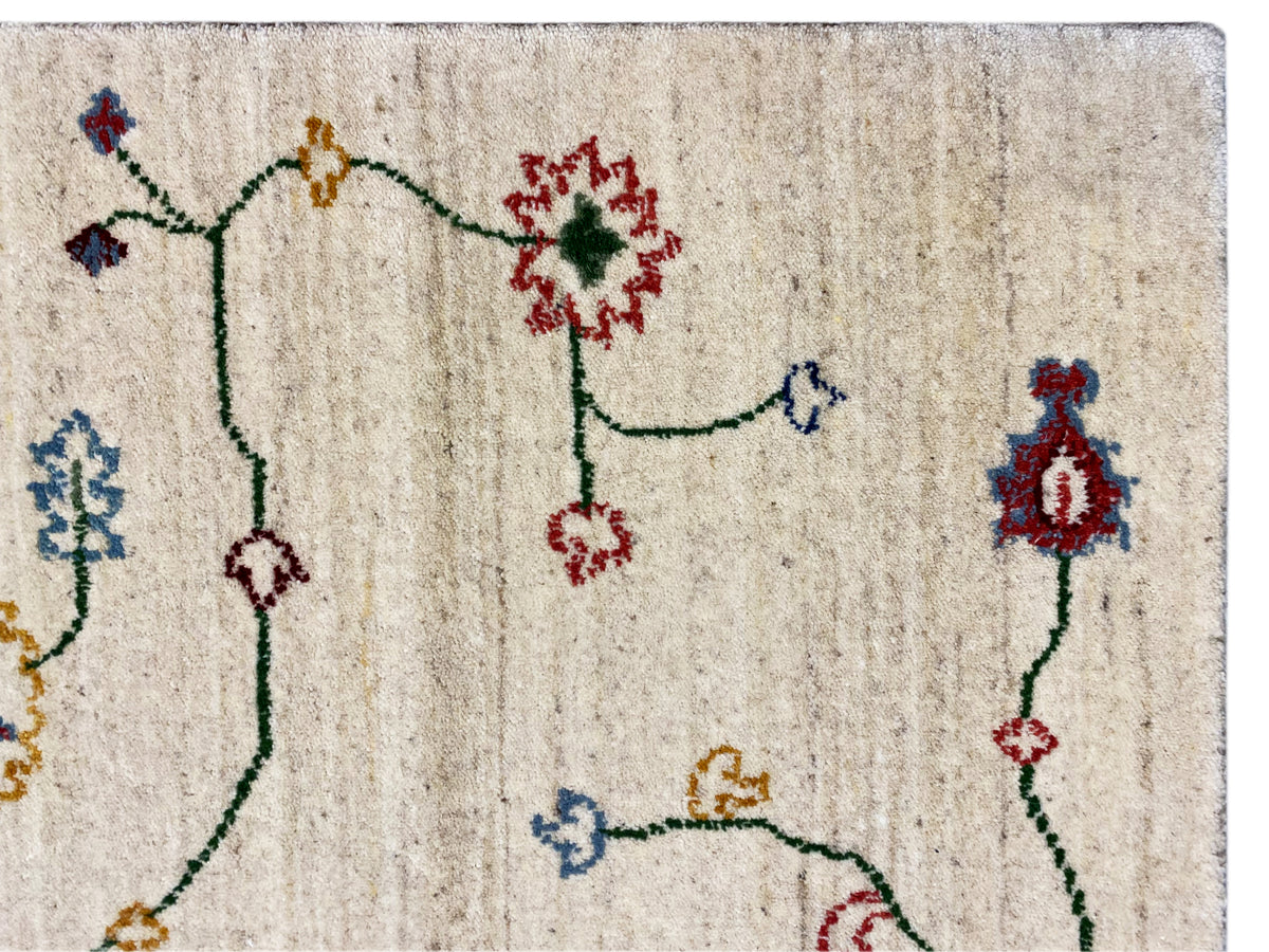 Teppichdetail: cremefarbener Flor mit bunten Blumensymbolen und feinen Linien.