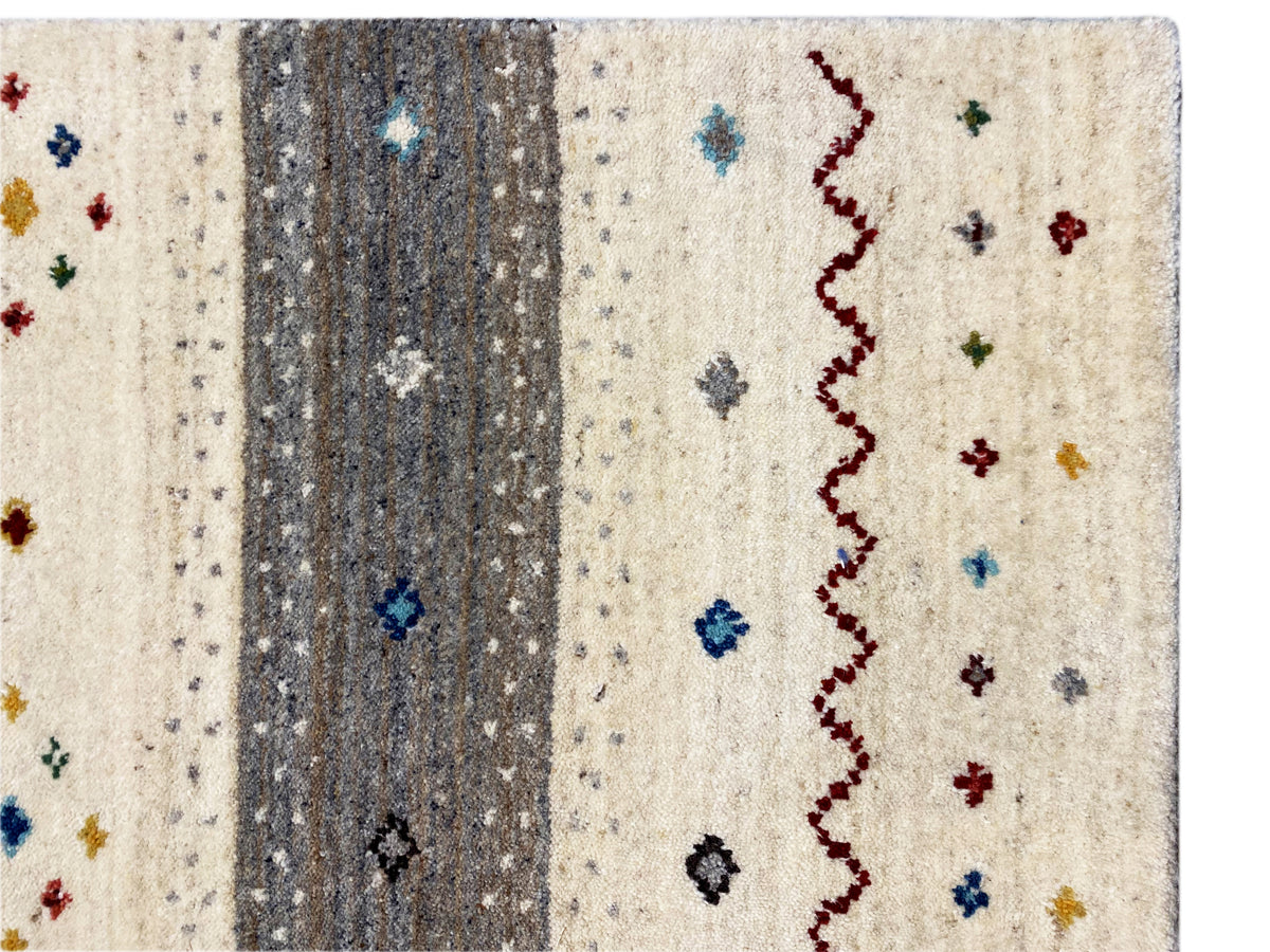 Nahaufnahme Teppich: beiger Flor mit grauem Streifen und roten Zickzacklinien