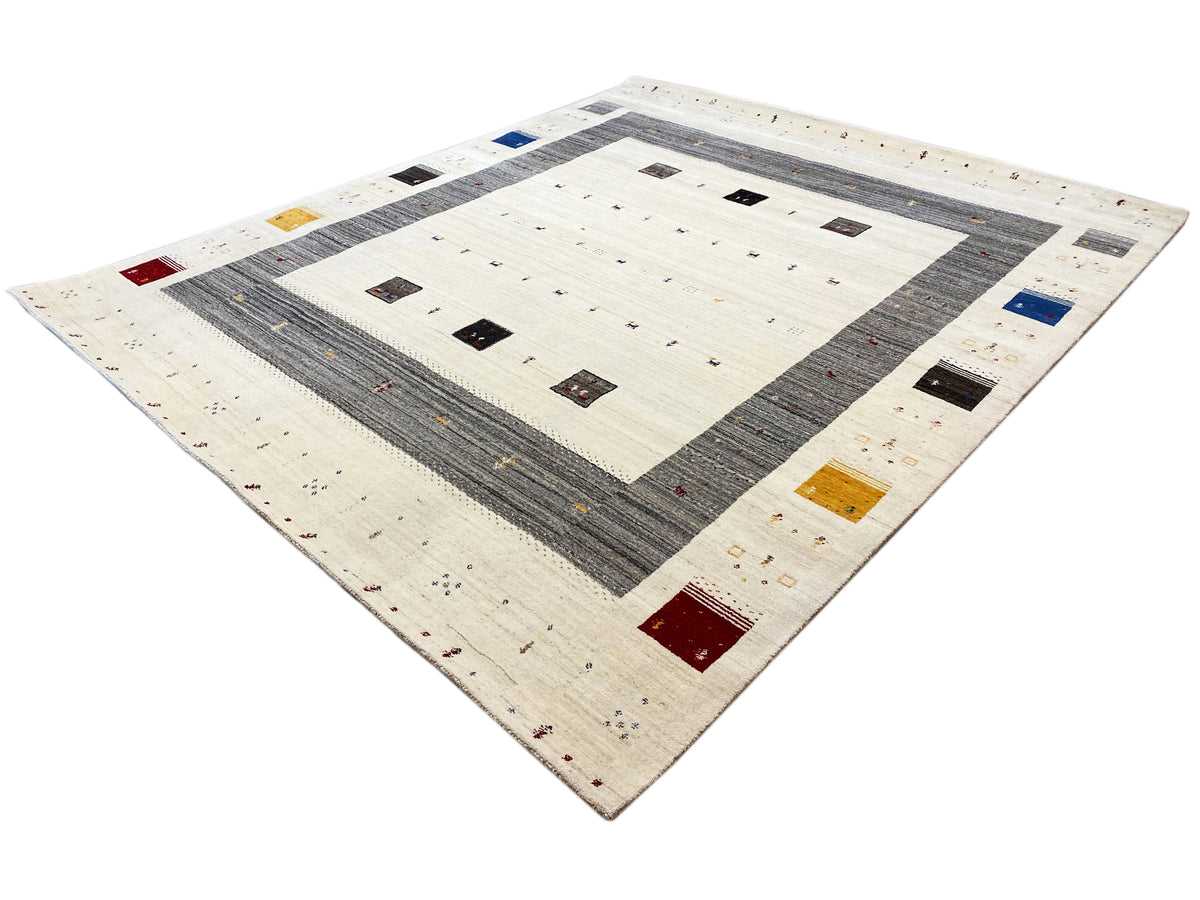 Quadratischer Blick: creme Teppichfläche mit dunkelgrauem Mittelband und Farbakzenten