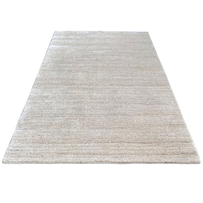 Rectangular rug in light beige with a fine, speckled woven texture