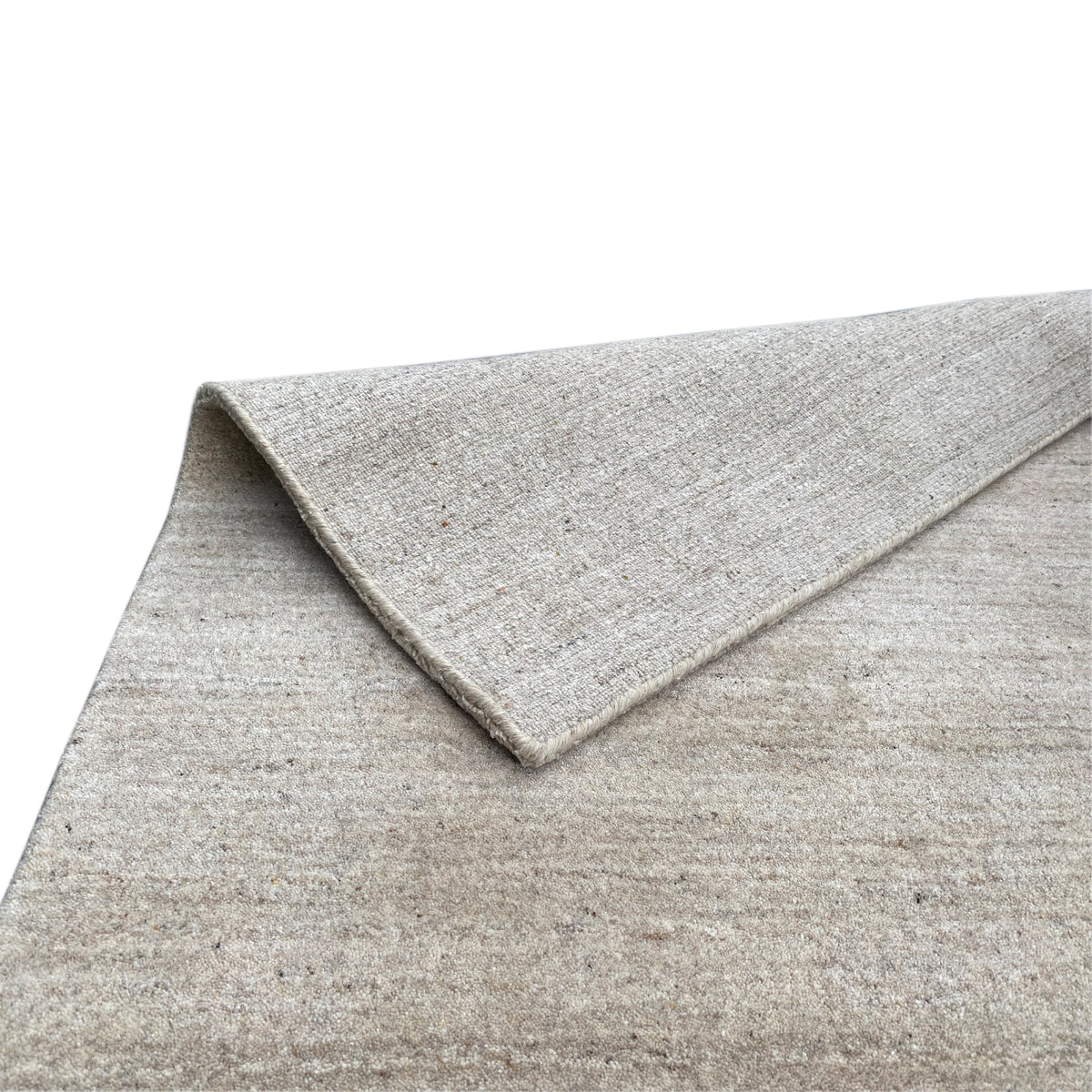 Close-up: beige carpet with a turned-up edge and subtly mottled surface